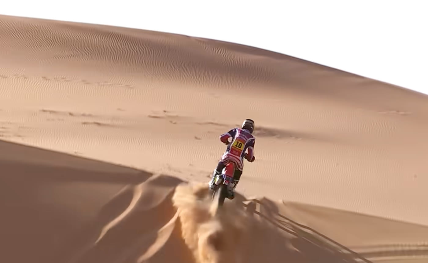 Pilote moto du Dakar à l'attaque d'une dune, dossard 10